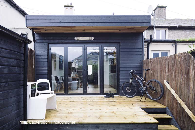 Exterior view of extension with patio glass doors and furniture timber decking and cladding