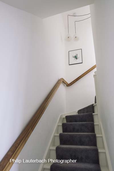 Hallway stairs pendant lighting carpeting artwork