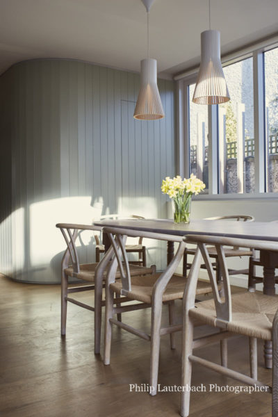 Dining area, chairs, table, pendant lighting,timber paneling curved